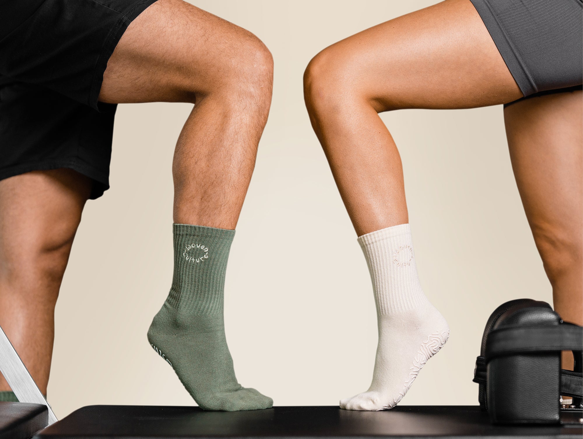 Man and woman wearing organic cotton grip socks in green and cream during a Pilates workout – Woven Culture.