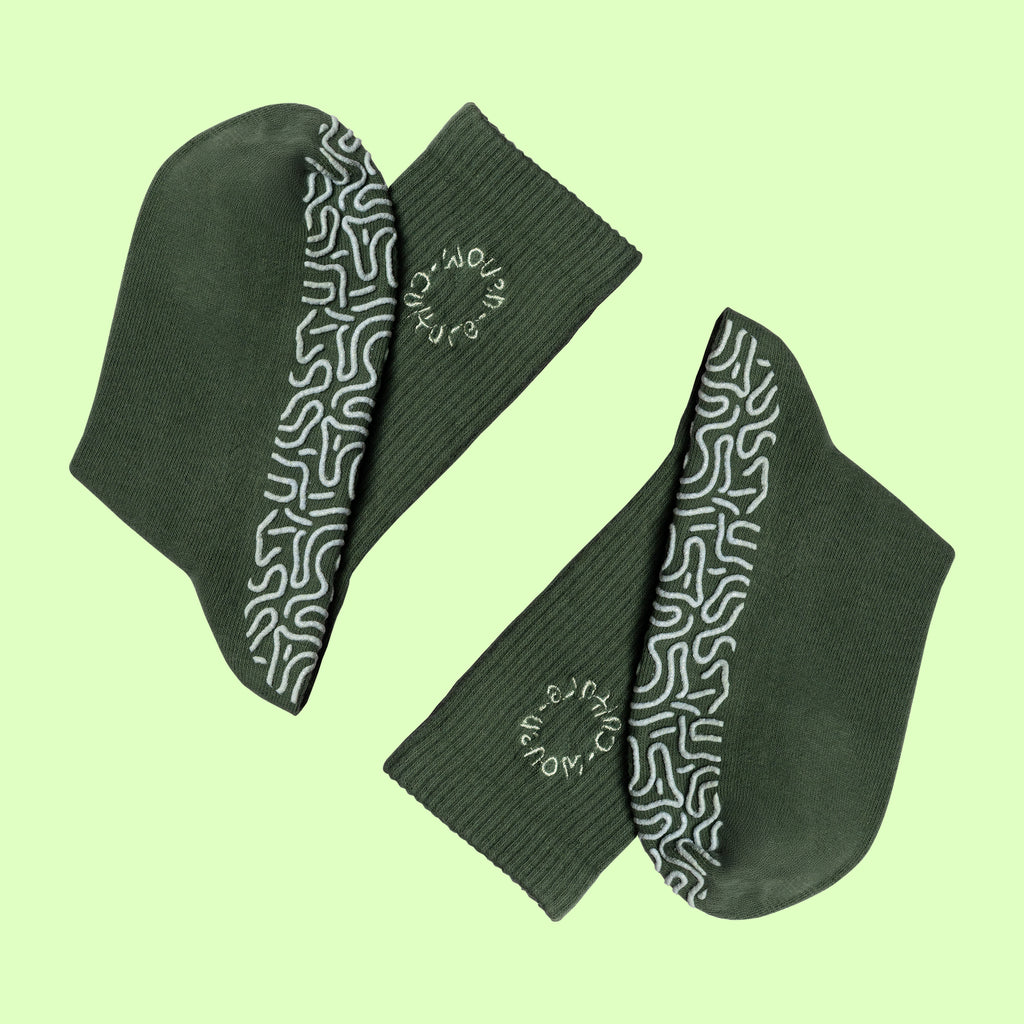 Green organic cotton grip socks with non-slip sole pattern and Woven Culture logo, eco-friendly Pilates and yoga socks.
